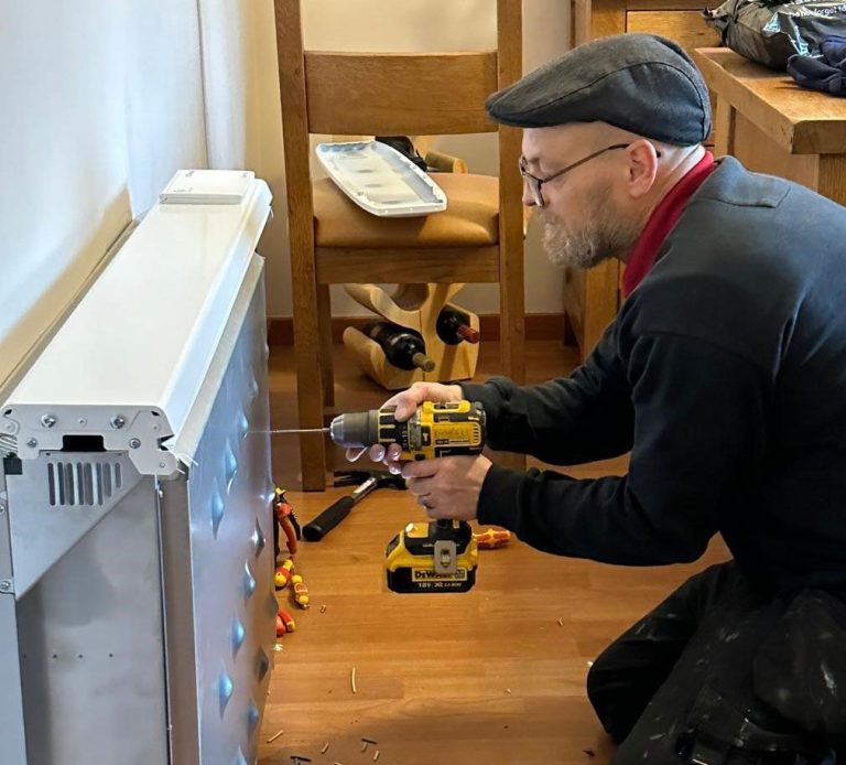 KF Watson engineer working on a Dimplex electric wall mounted heater / radiator