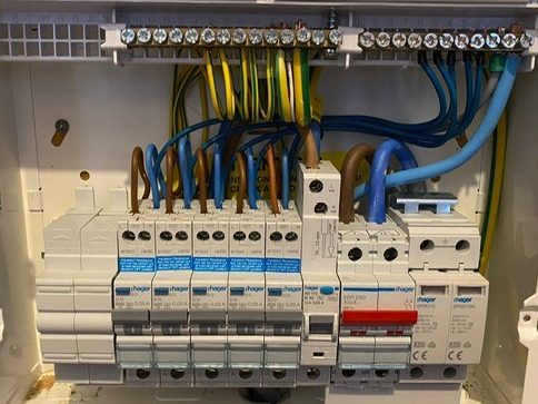 Inside view of a consumer unit (fuse box) fitted by KF Watson showing switches and wiring